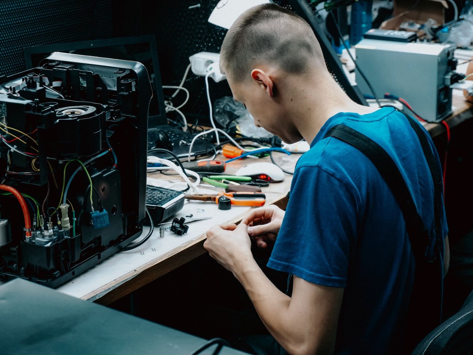 A technician at a workbench repairing an appliance