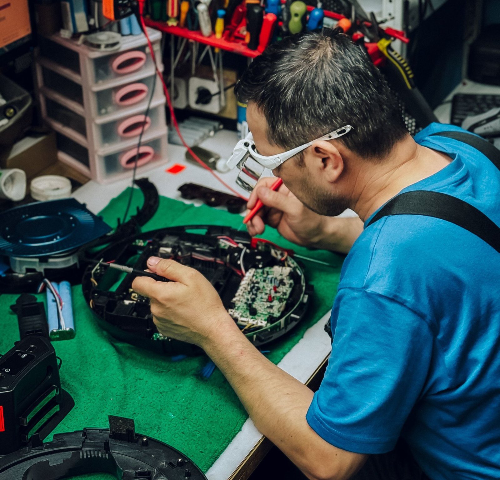 A technician repairing an appliance part at a workbench