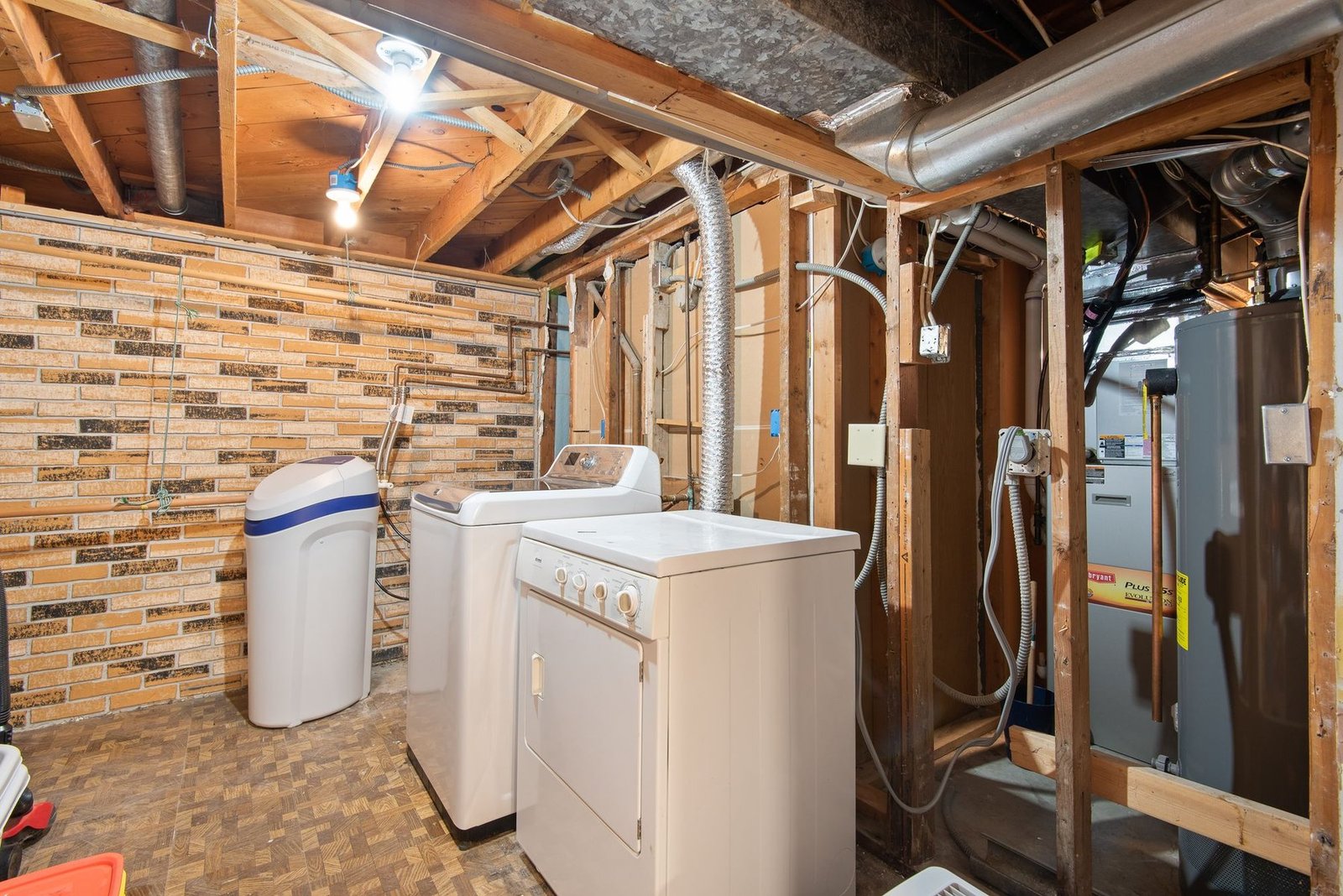 A white top load washing machine and dryer in a laundry room